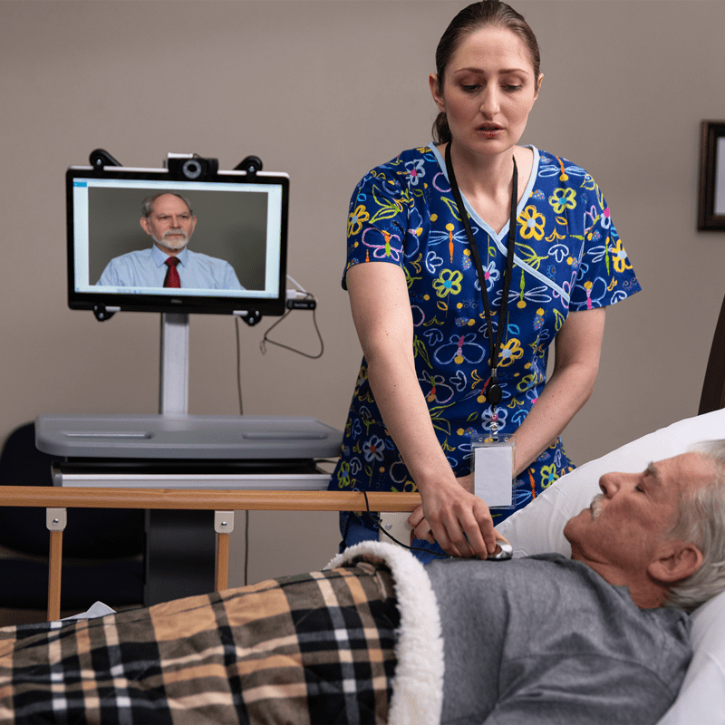Nursing checking on patient while Dr. Chess watches from Telemedicine device